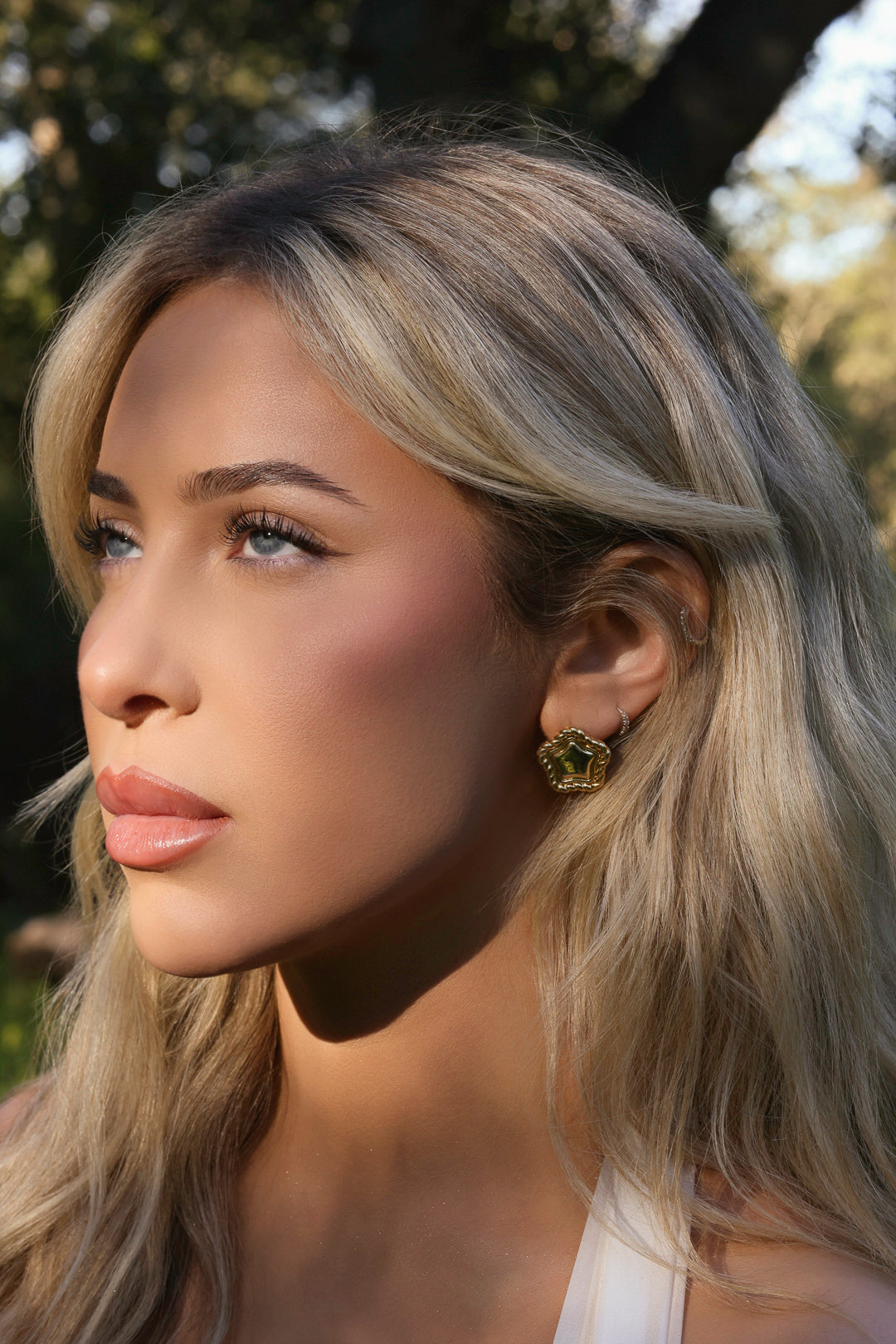 LA FORZA Daisy Earrings close-up on model showing textured border detail